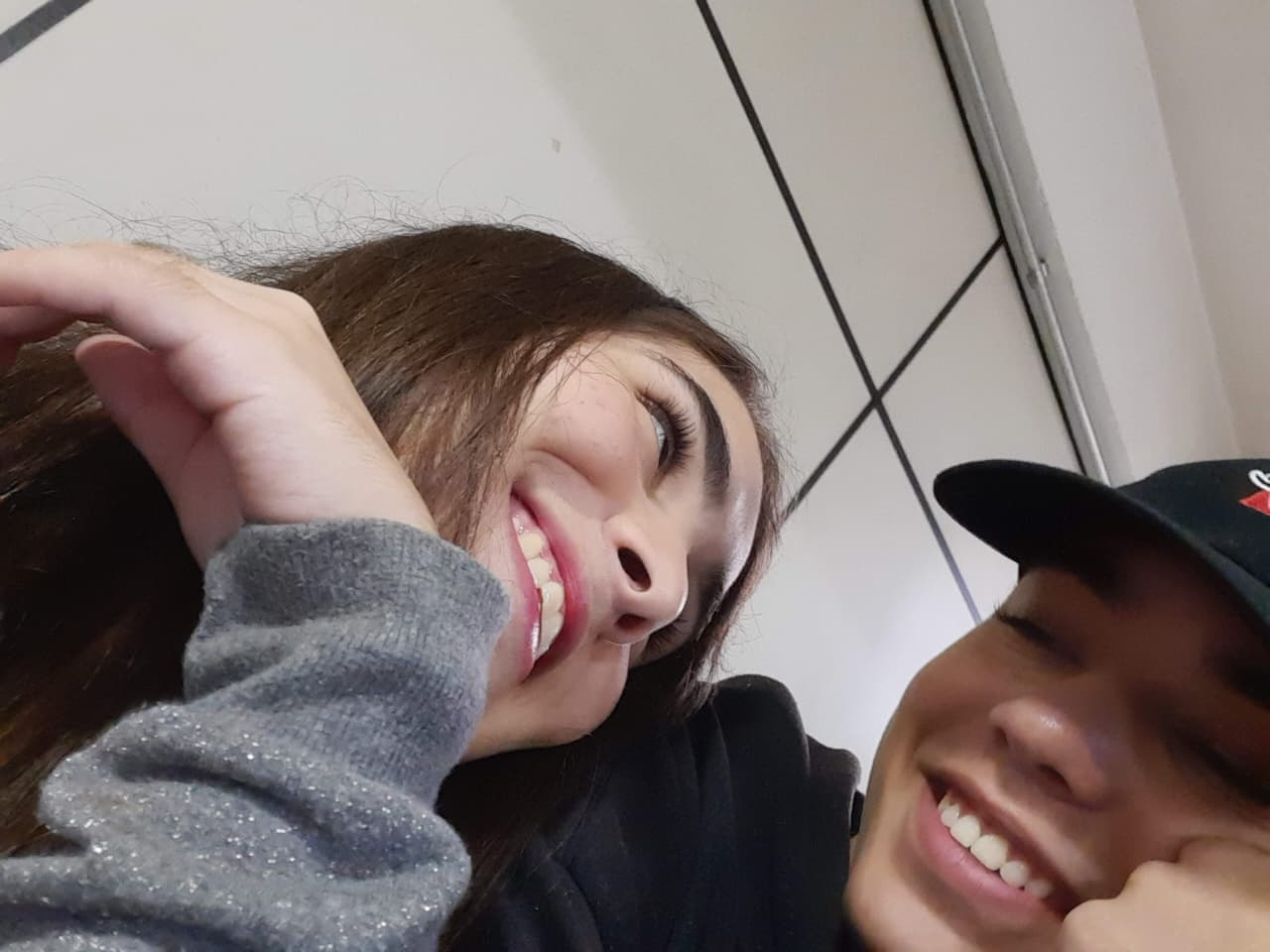 Isa e João sorrindo juntos em um registro descontraído